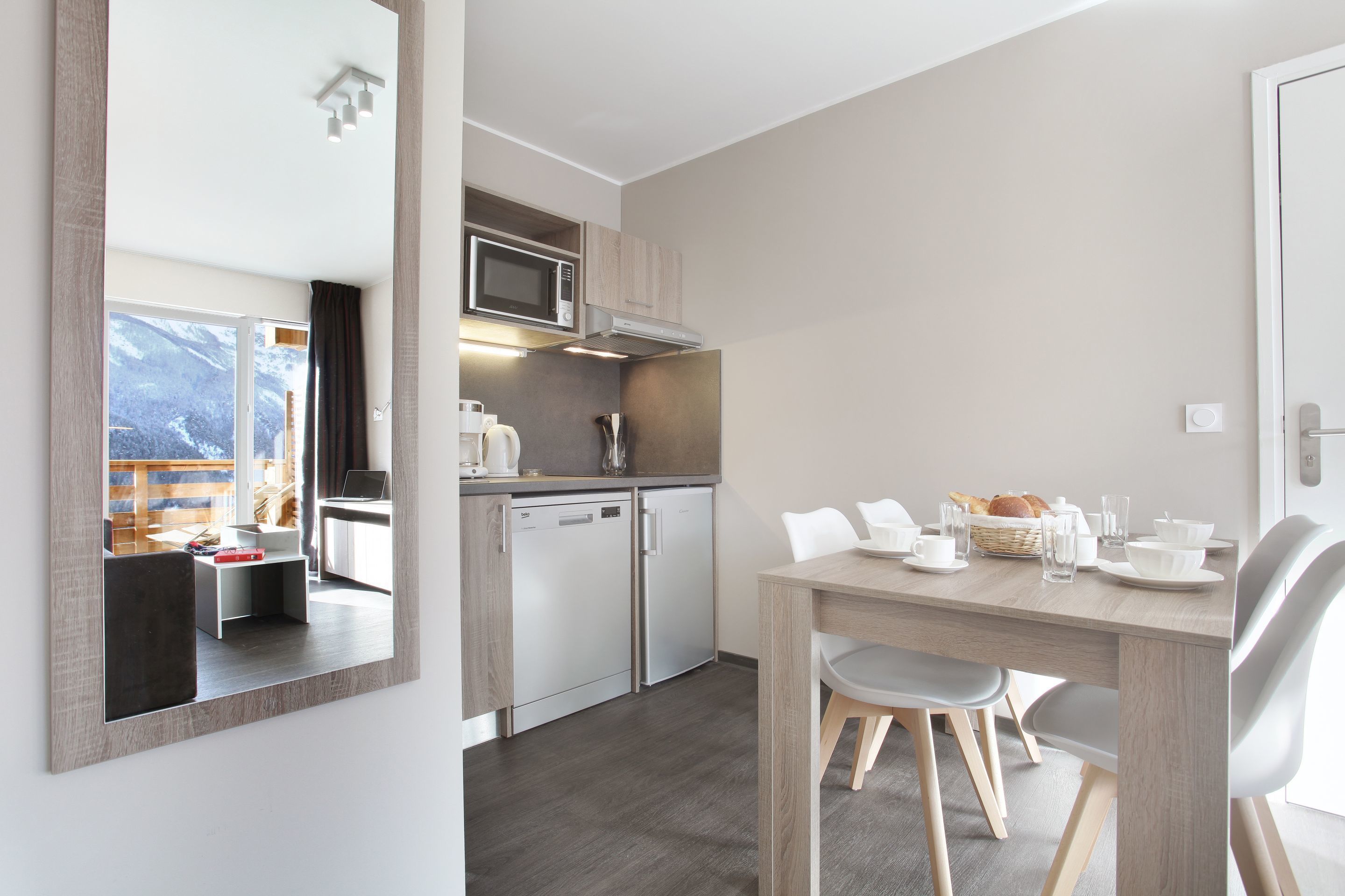 Una cocina moderna con microondas, lavavajillas y armarios de madera.