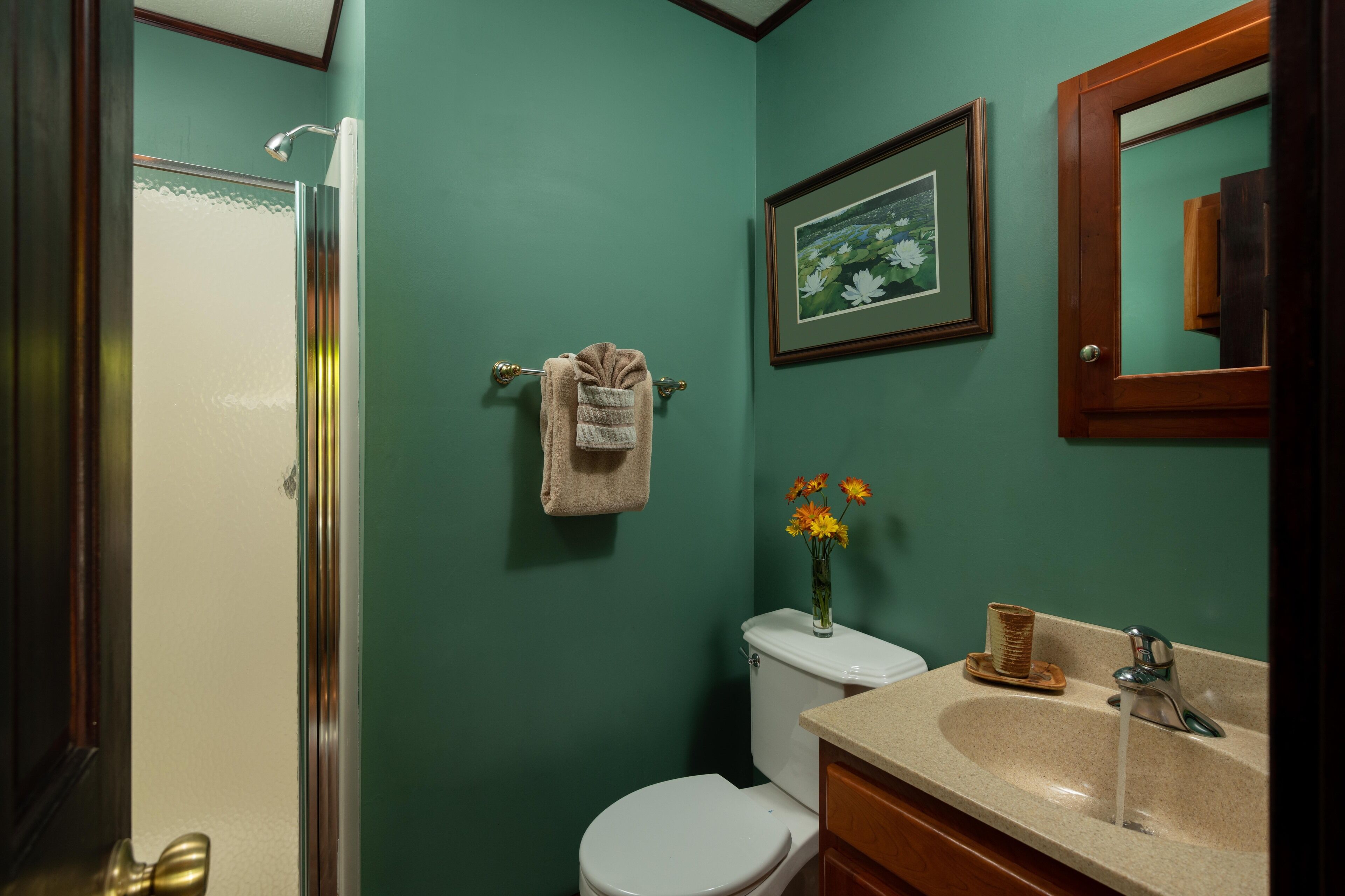 A bathroom with a toilet, sink, and shower.