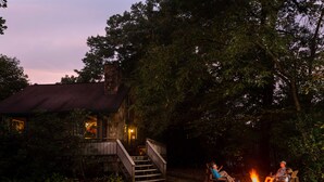 A rustic cabin with a wooden staircase leading to a porch, surrounded by trees. - Paddler's Lane Retreat (Confluence)