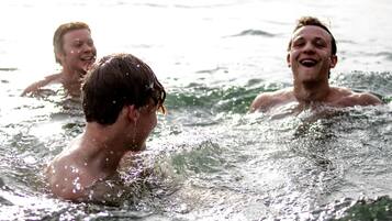 Tres personas nadando en un cuerpo de agua.