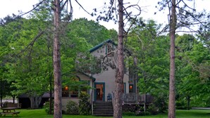 A cabin with a porch, surrounded by trees. - Paddler's Lane Retreat (Confluence)