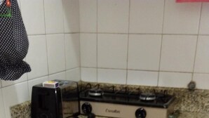 A kitchen with a toaster, a gas stove, a microwave, and a coffee maker. - Studio One (Rio de Janeiro)