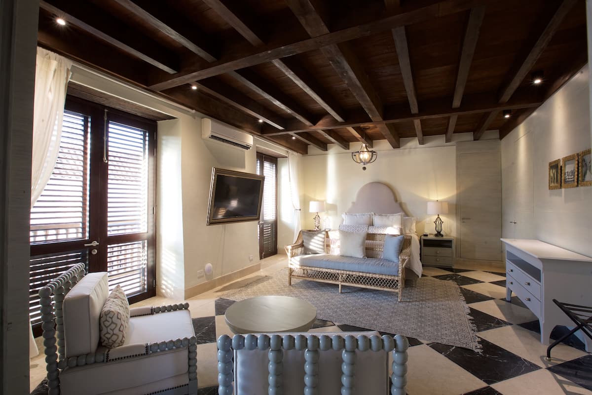 Un dormitorio con cama, televisión, mesita de noche y cómoda.