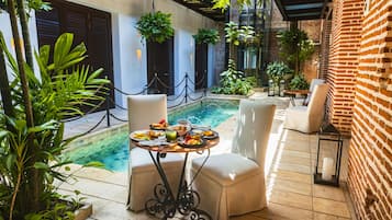 Enjoy a meal al fresco in this serene outdoor dining area, surrounded by lush greenery and a tranquil atmosphere.