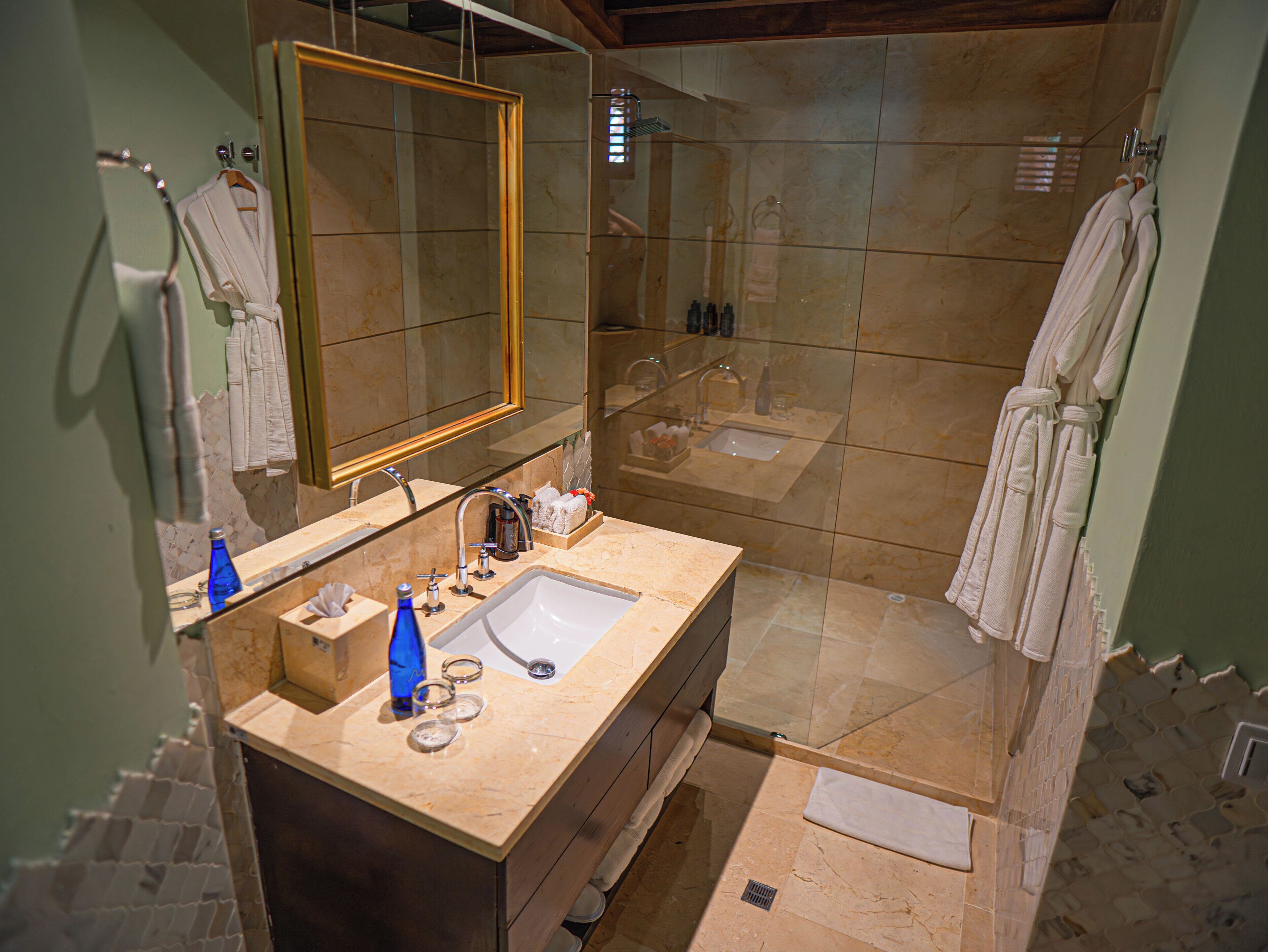 Un baño con lavabo, espejo y ducha.