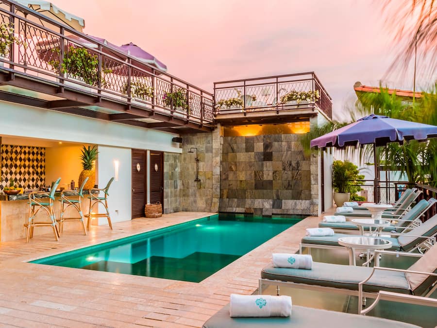 Una piscina cubierta, una piscina al aire libre, sombrillas, tumbonas