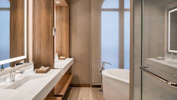 Une salle de bain moderne avec un grand miroir, deux lavabos, une baignoire et une douche.