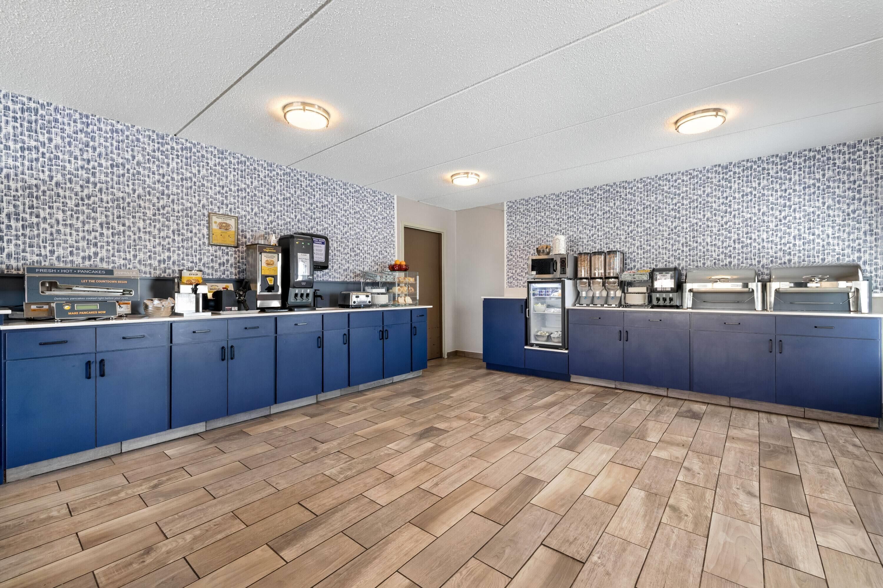 Una cocina con armarios azules, una cafetera y un microondas.