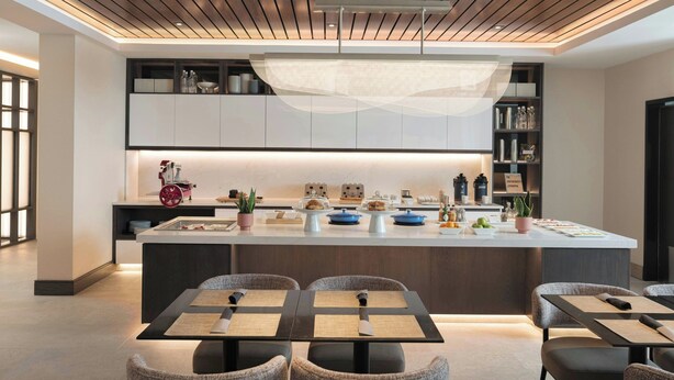 A modern kitchen with a central island, built-in cabinets, and a pendant light. - AC Hotel by Marriott Asheville Biltmore Village (Asheville)