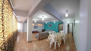 A spacious living area with a dining table, chairs, a sofa, and a television. - Space (Cochabamba)