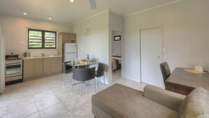 Un espacio habitable compacto con kitchenette, comedor y sofá.