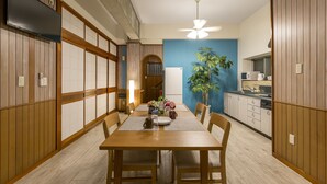 Ein Essbereich mit Holztisch, Stühlen und Deckenventilator.