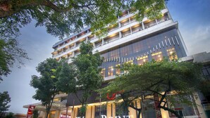 Un hôtel à plusieurs étages, doté d’une façade moderne, de grandes fenêtres et d’une entrée imposante.