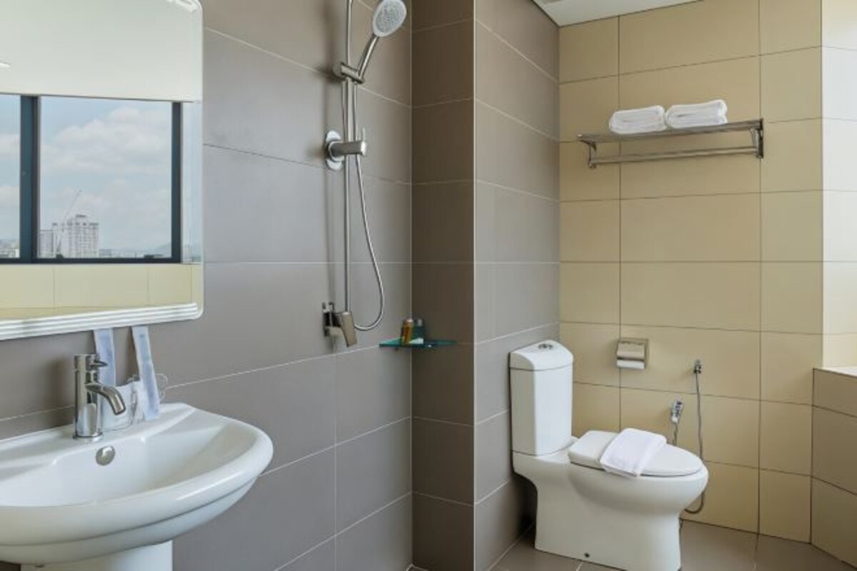 Un baño moderno con lavamanos, inodoro y ducha.