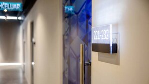 A hotel corridor with a door labeled "221-232" and a sign above indicating "KELUAR".