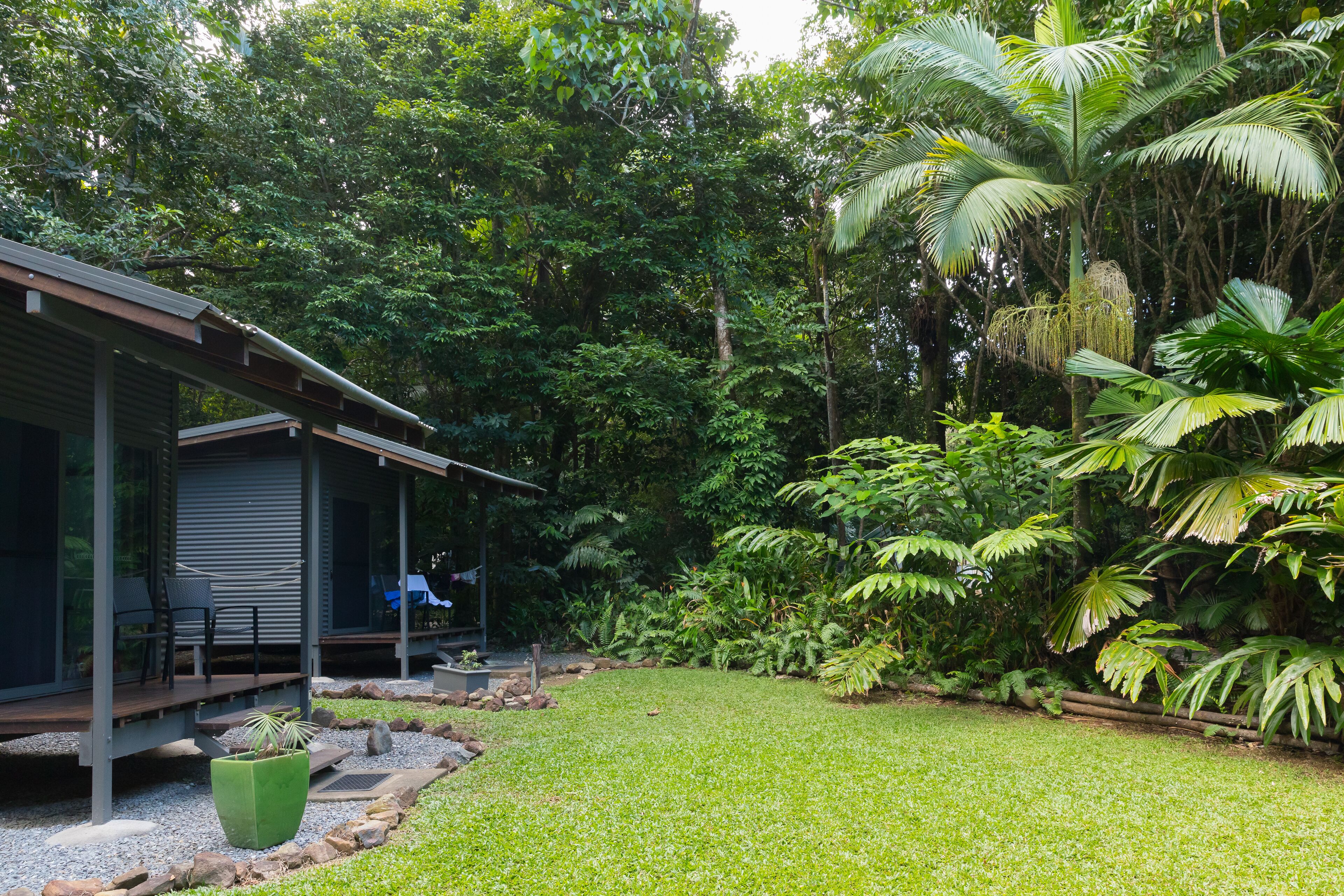 A modern house with a covered porch, surrounded by lush greenery and a well-maintained lawn.
