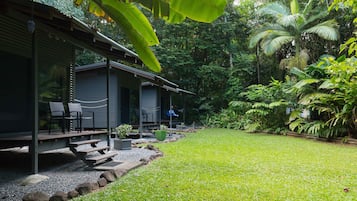 Relax in a serene outdoor space with a covered patio, lush greenery, and a tranquil atmosphere.