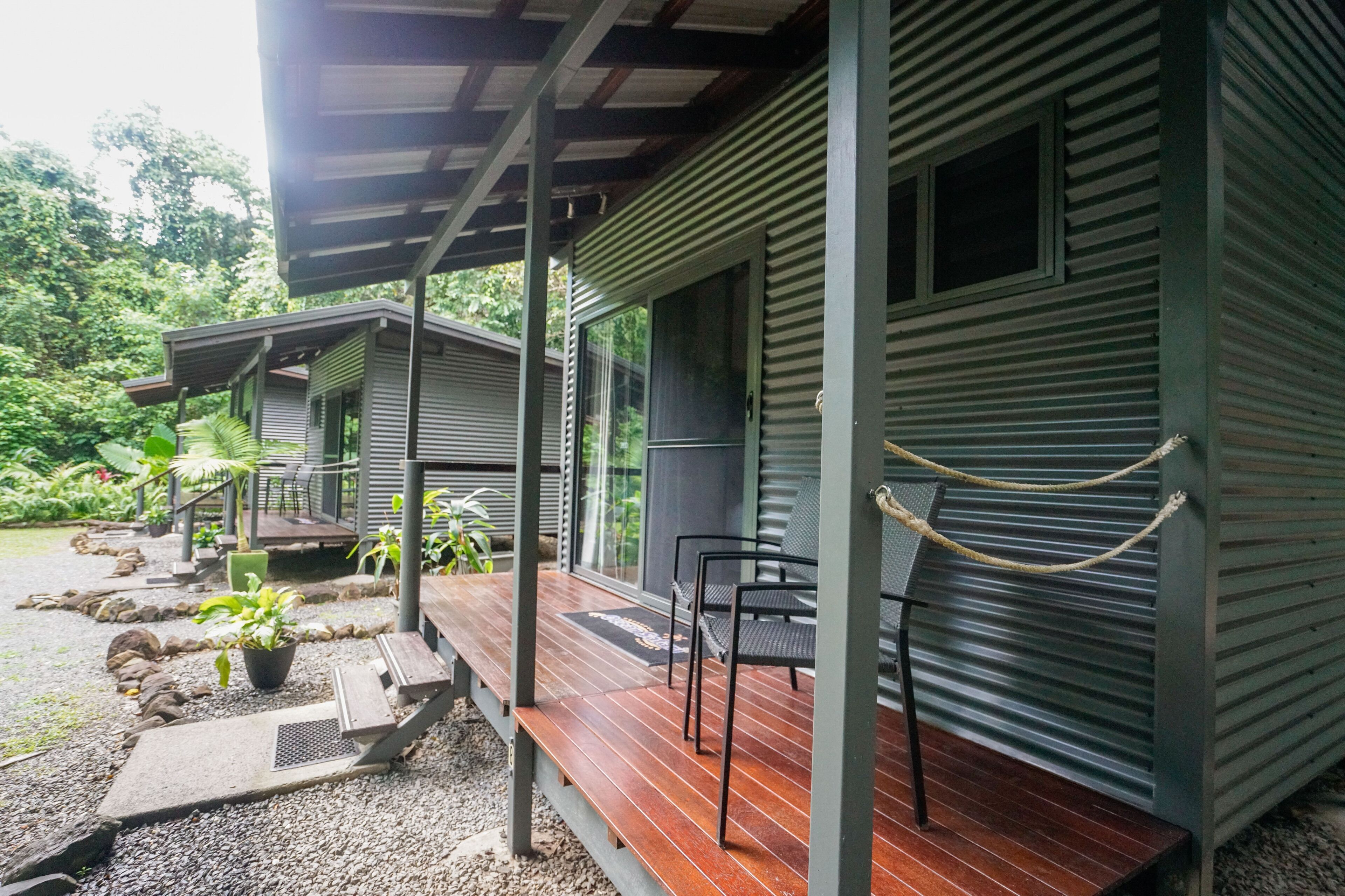 A covered outdoor area with a wooden deck, metal railing, and a rope barrier.