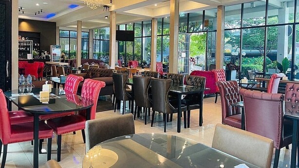 Un comedor amplio con techos altos, ventanas grandes y mobiliario moderno.