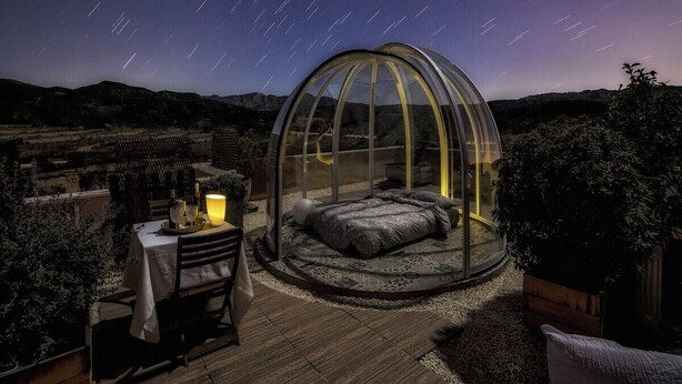 A dome-shaped room with a bed, a table with a candle, and a view of the night sky. - El Pao  (Jijona)