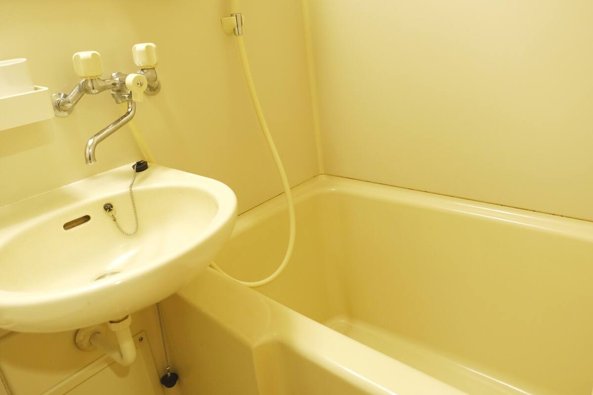 A bathroom with a white sink, a bathtub, and a shower.