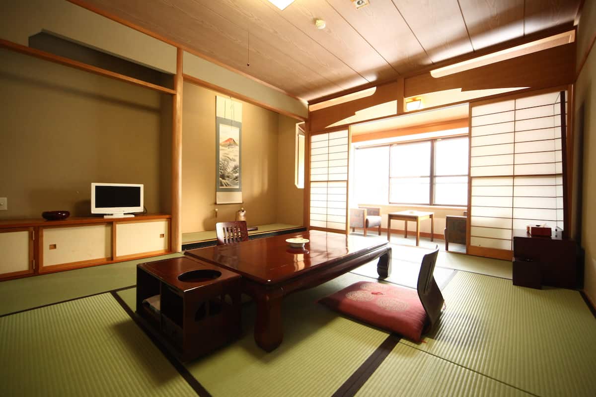 A traditional Japanese room with tatami flooring, a low wooden table, and sliding shoji doors.
