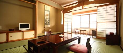 A traditional Japanese room with tatami flooring, a low wooden table, and sliding shoji doors.