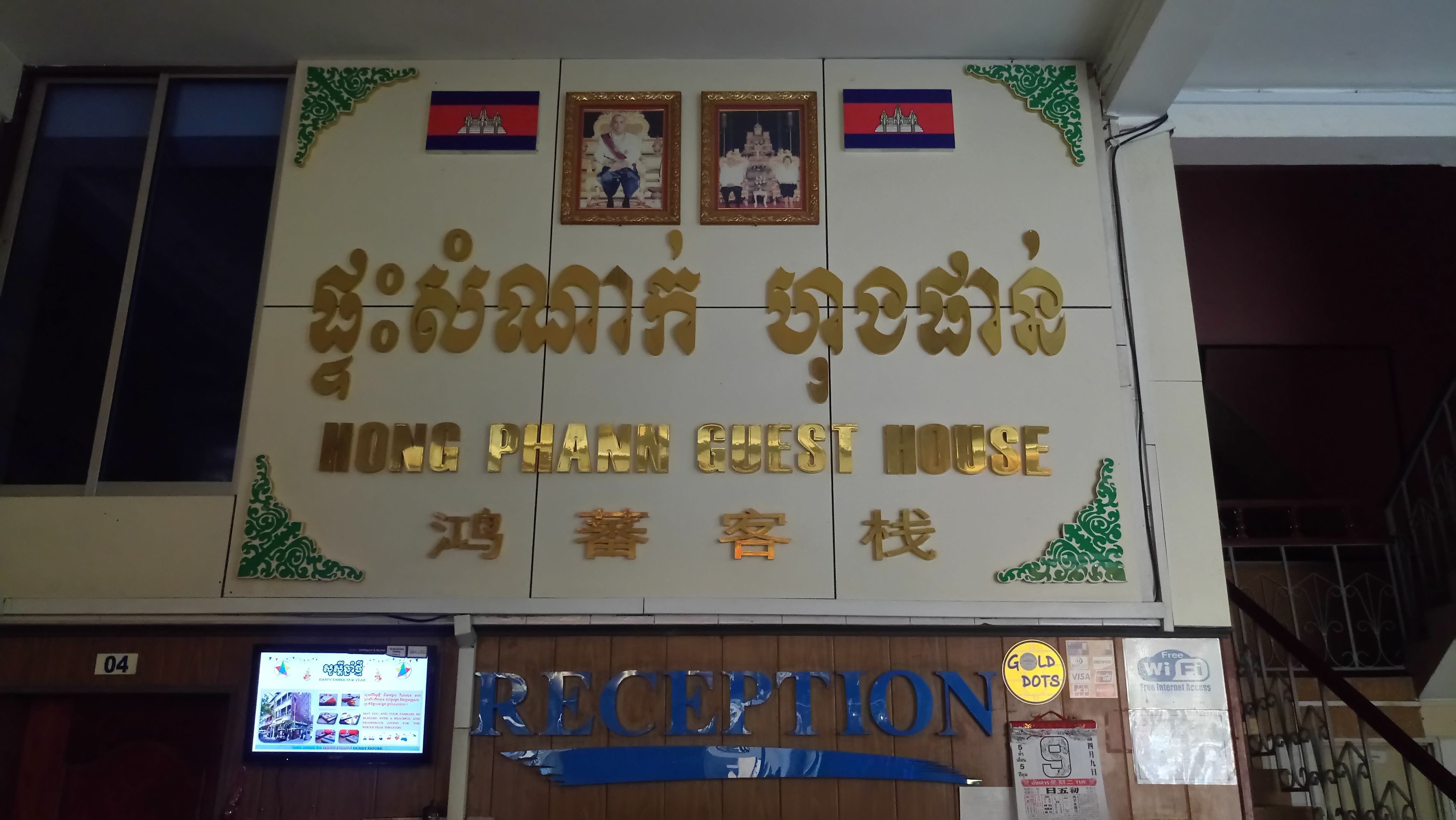 Señal de hotel con varios idiomas y una recepción debajo.