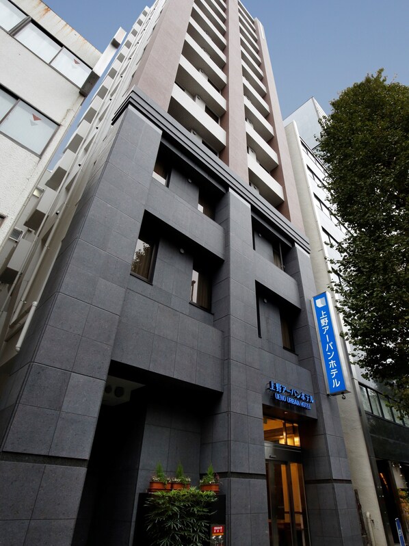 Un moderno edificio de hotel con un cartel que indica que es el UENO URBAN HOTEL.
