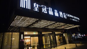 A hotel entrance with illuminated signage and a modern glass facade. - Crown Crystal Hotel (Shanghai)