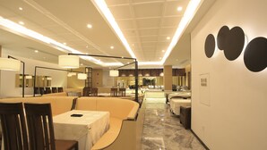 A modern hotel lobby with a seating area, a reception desk, and a large mirror. - Crown Crystal Hotel (Shanghai)