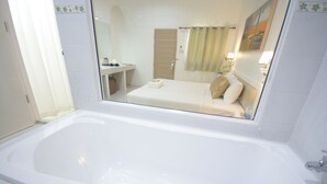 A modern bathroom with a large bathtub, a separate shower area, and a vanity with a mirror. - iRest Ao Nang Seafront (Krabi)