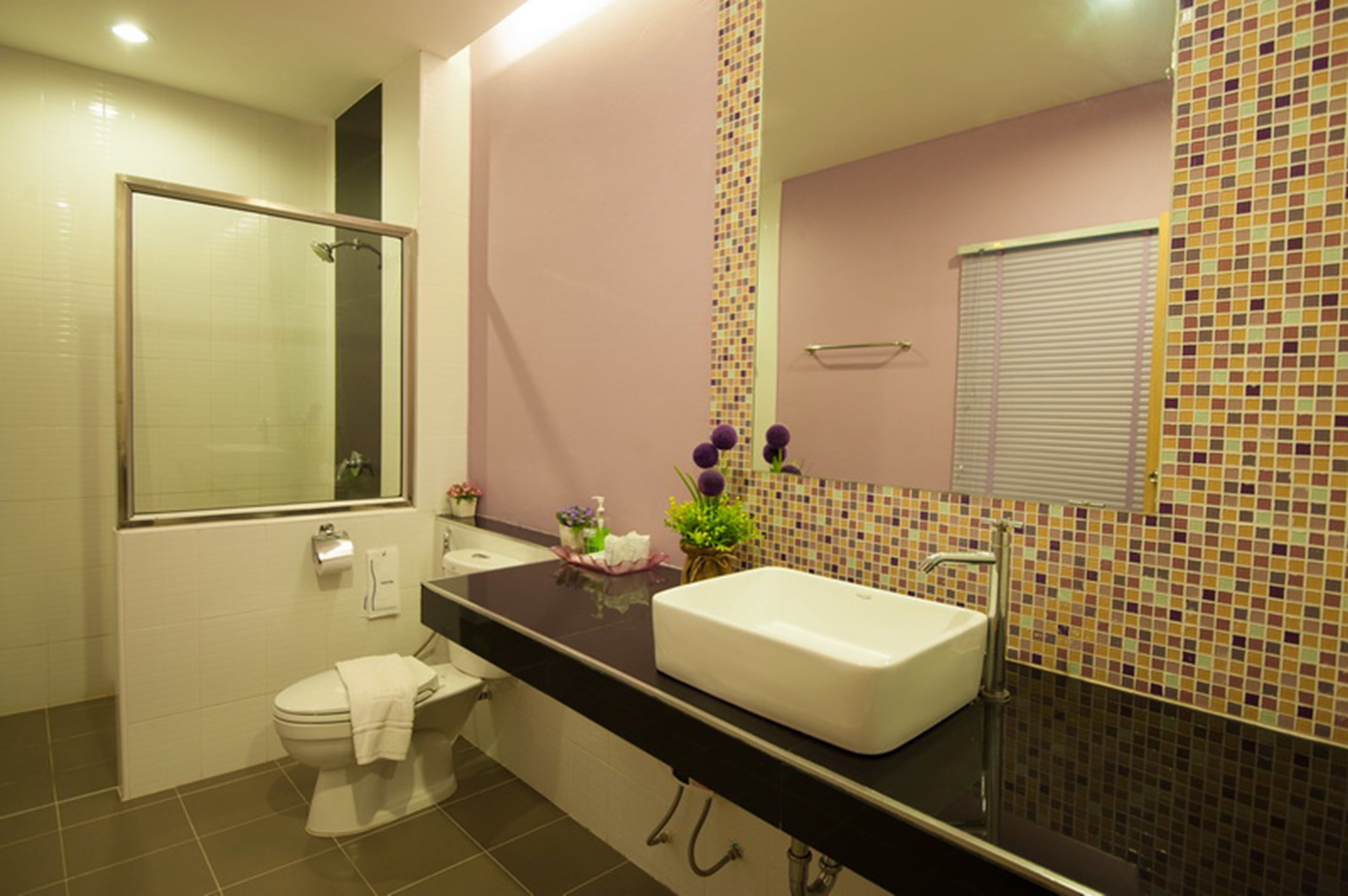 A bathroom with a toilet, sink, and shower.