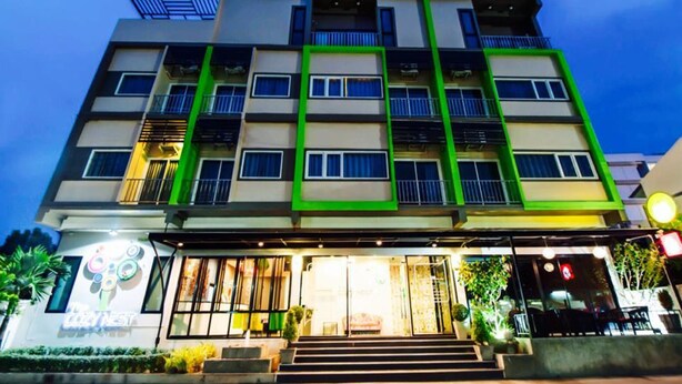 A multi-story hotel with a modern design, featuring balconies and a well-lit entrance.