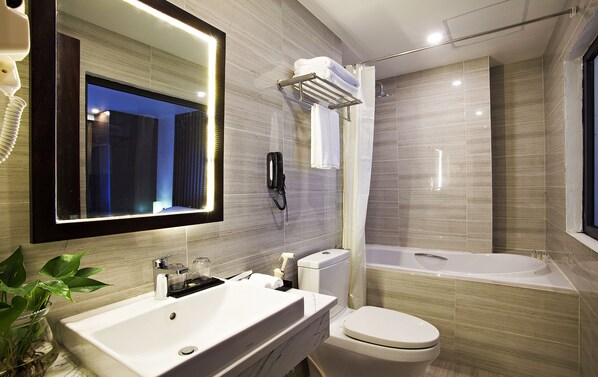 A modern bathroom with a large mirror, a sink, a toilet, and a bathtub. - Inearth Hotel Hanoi (Hanoi)