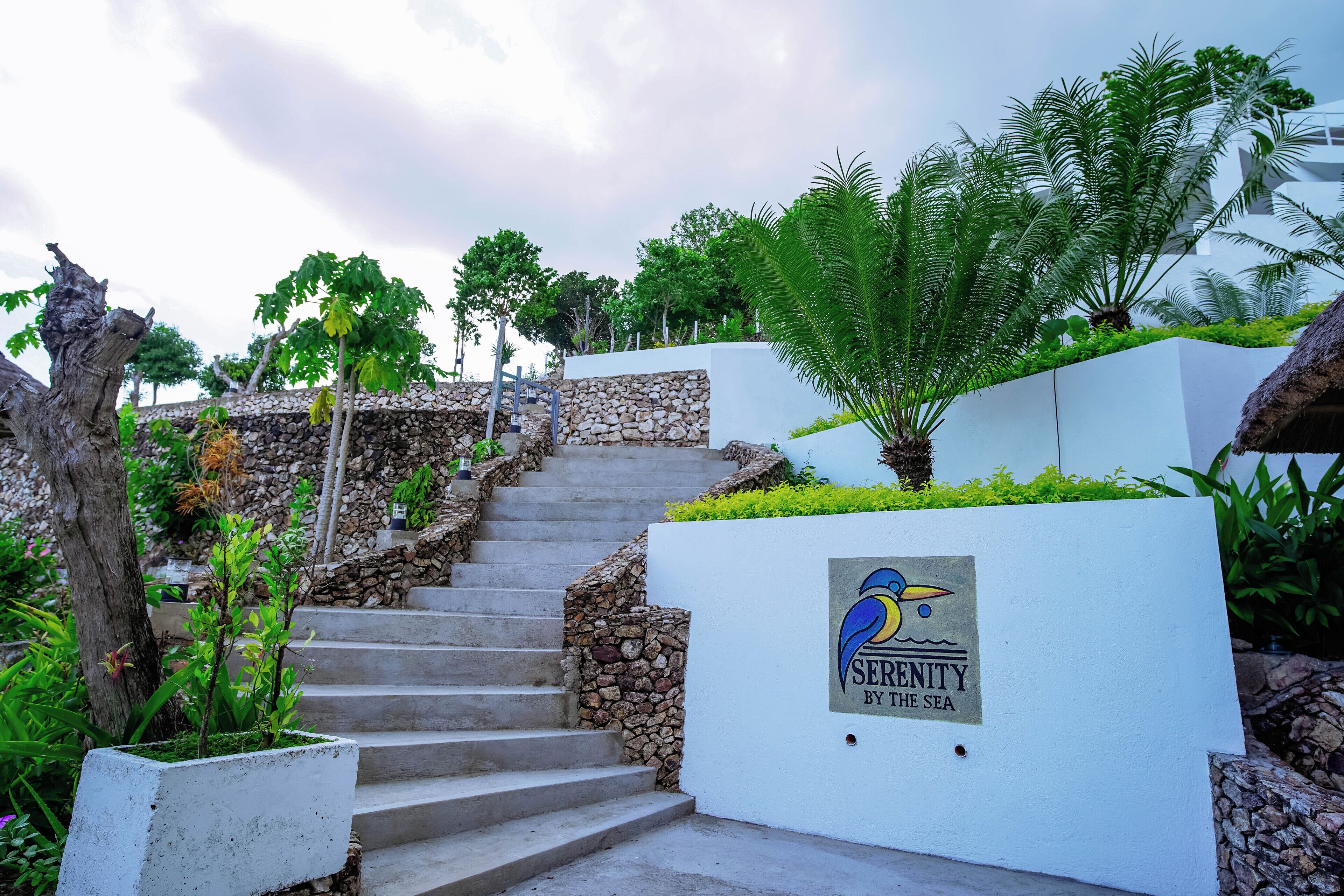 A staircase leading up to a building with a sign that reads "Serenity by the Sea".
