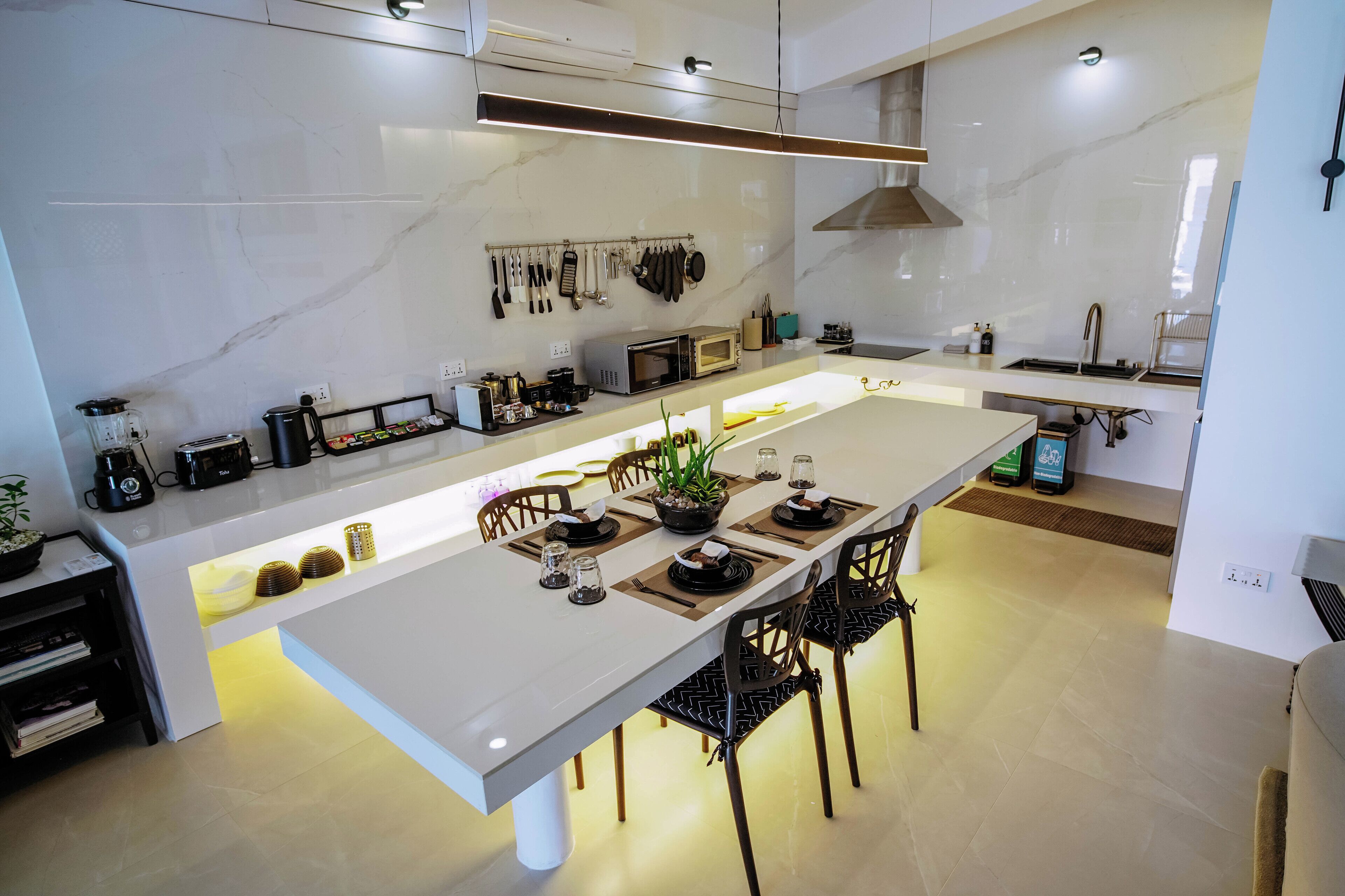 Una cocina moderna con una isla grande, equipada con microondas, tostadora y varios utensilios.
