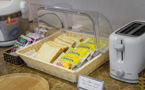 A breakfast buffet with bread, cheese, butter, and a toaster. - Cherry Hotel 1 (Hanoi)
