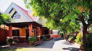 A house with a sloped roof and a covered porch. - Umaverde Bed & Breakfast (San Jose de Buenavista)