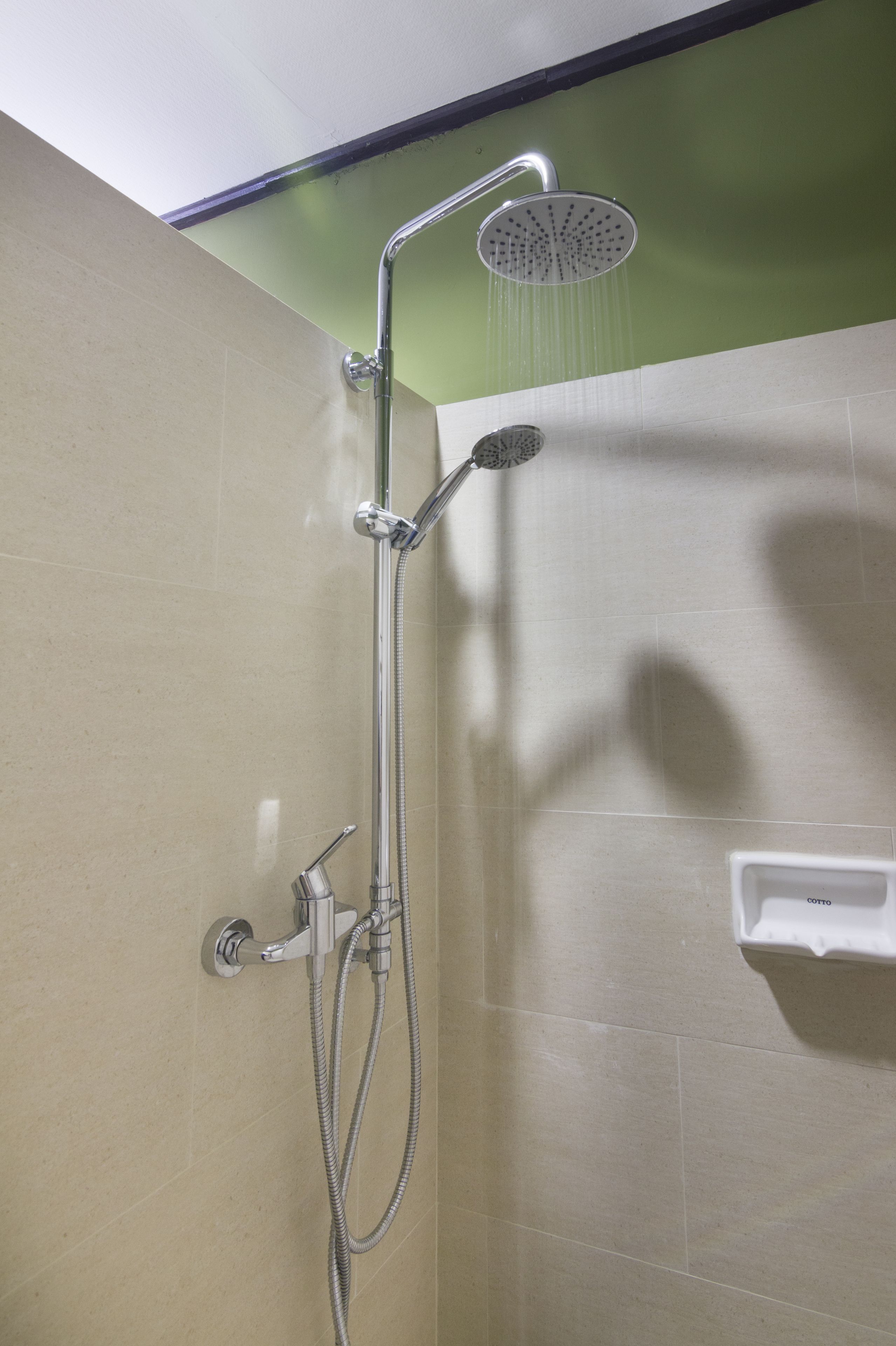 A shower with a handheld showerhead and a wall-mounted faucet.