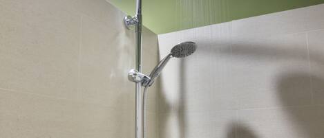 Eine Dusche mit Handbrause und Wandarmatur.