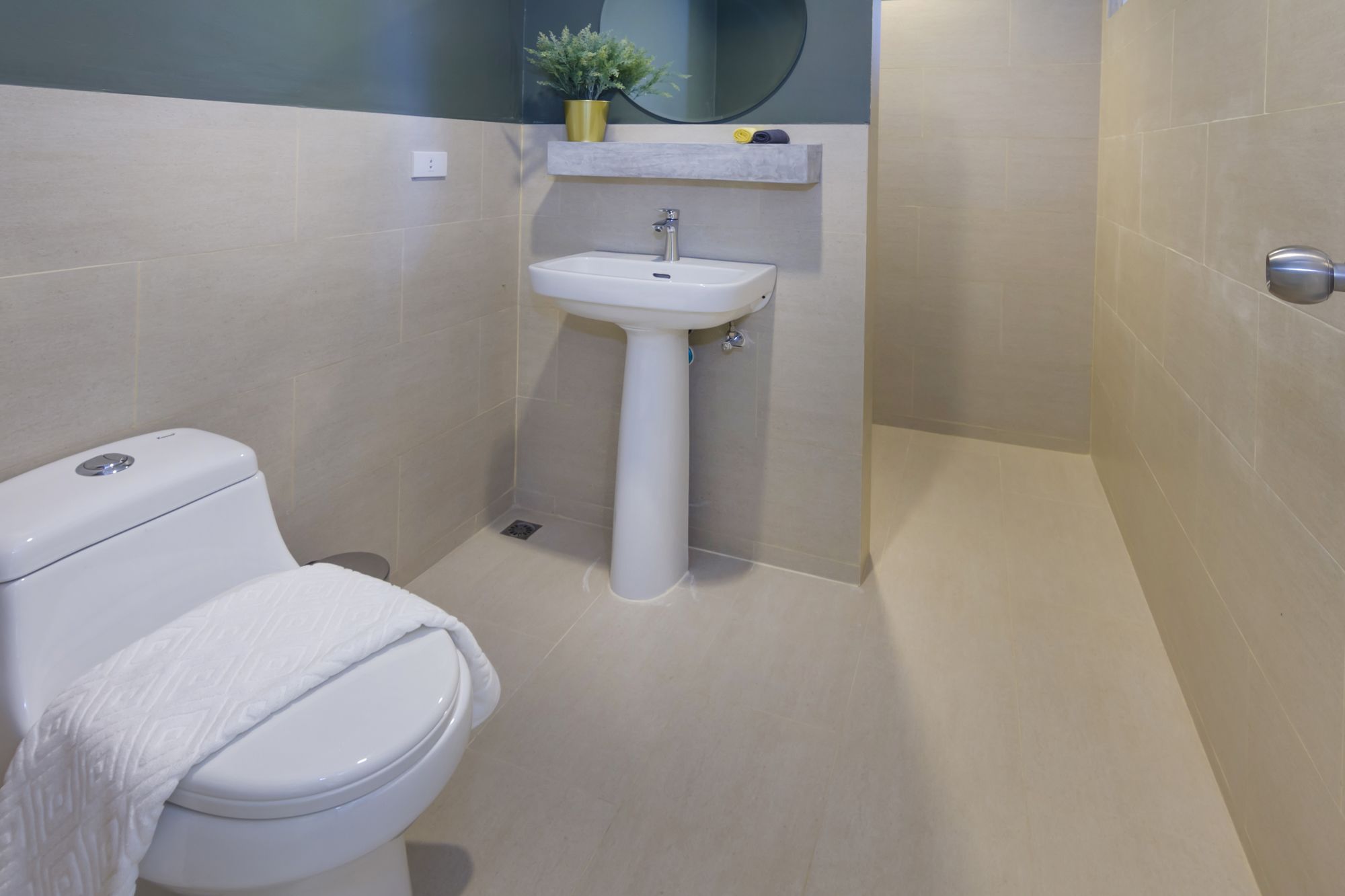 A compact bathroom with a toilet, sink, and shower area.