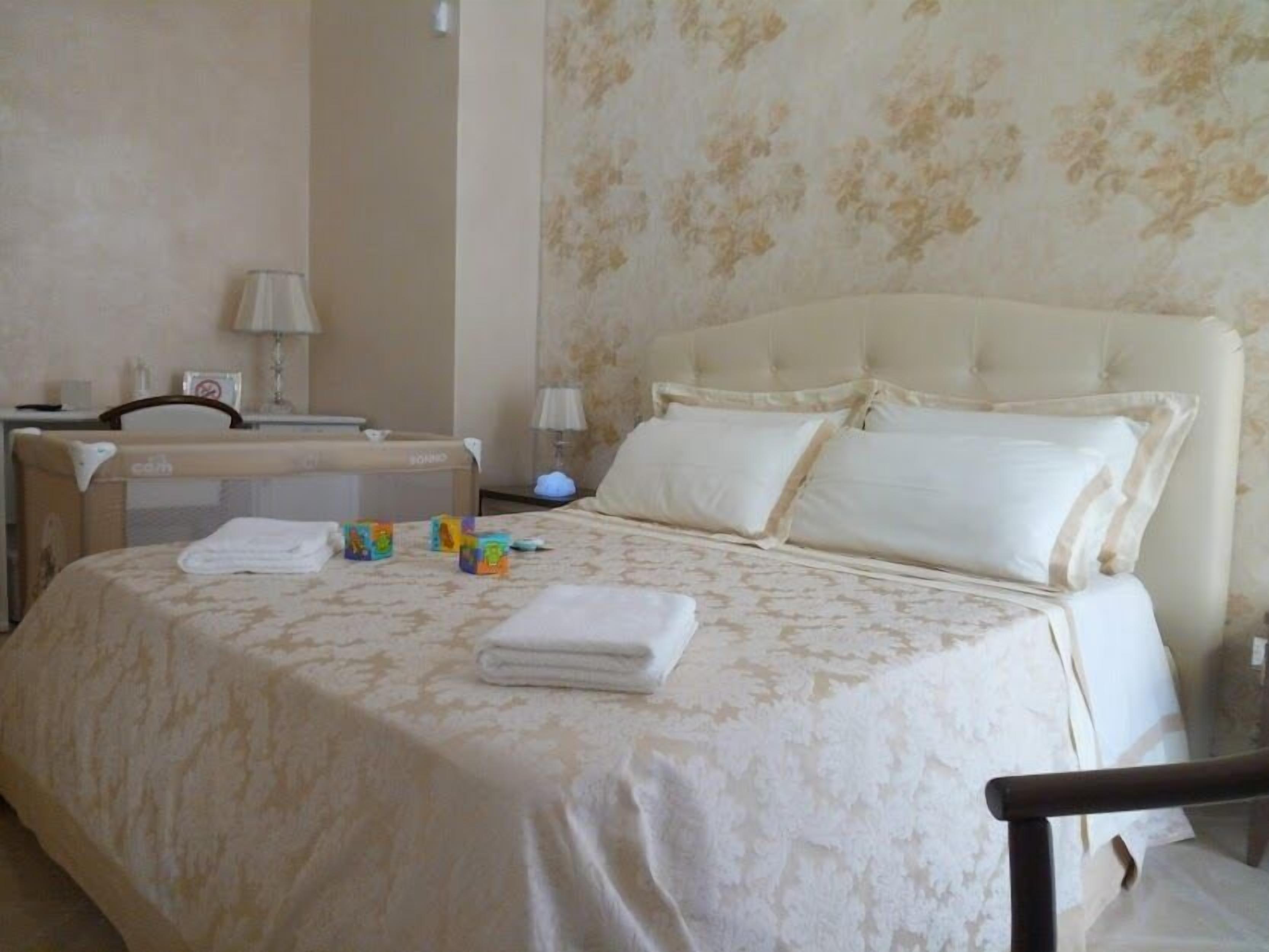 Una habitación de hotel con cama, escritorio, silla y mesita de noche.