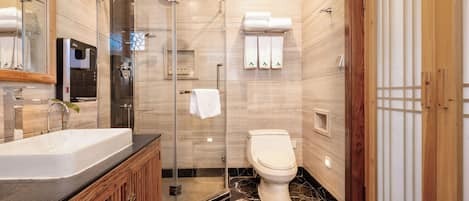 A modern bathroom with a glass-enclosed shower, a freestanding bathtub, and a toilet.