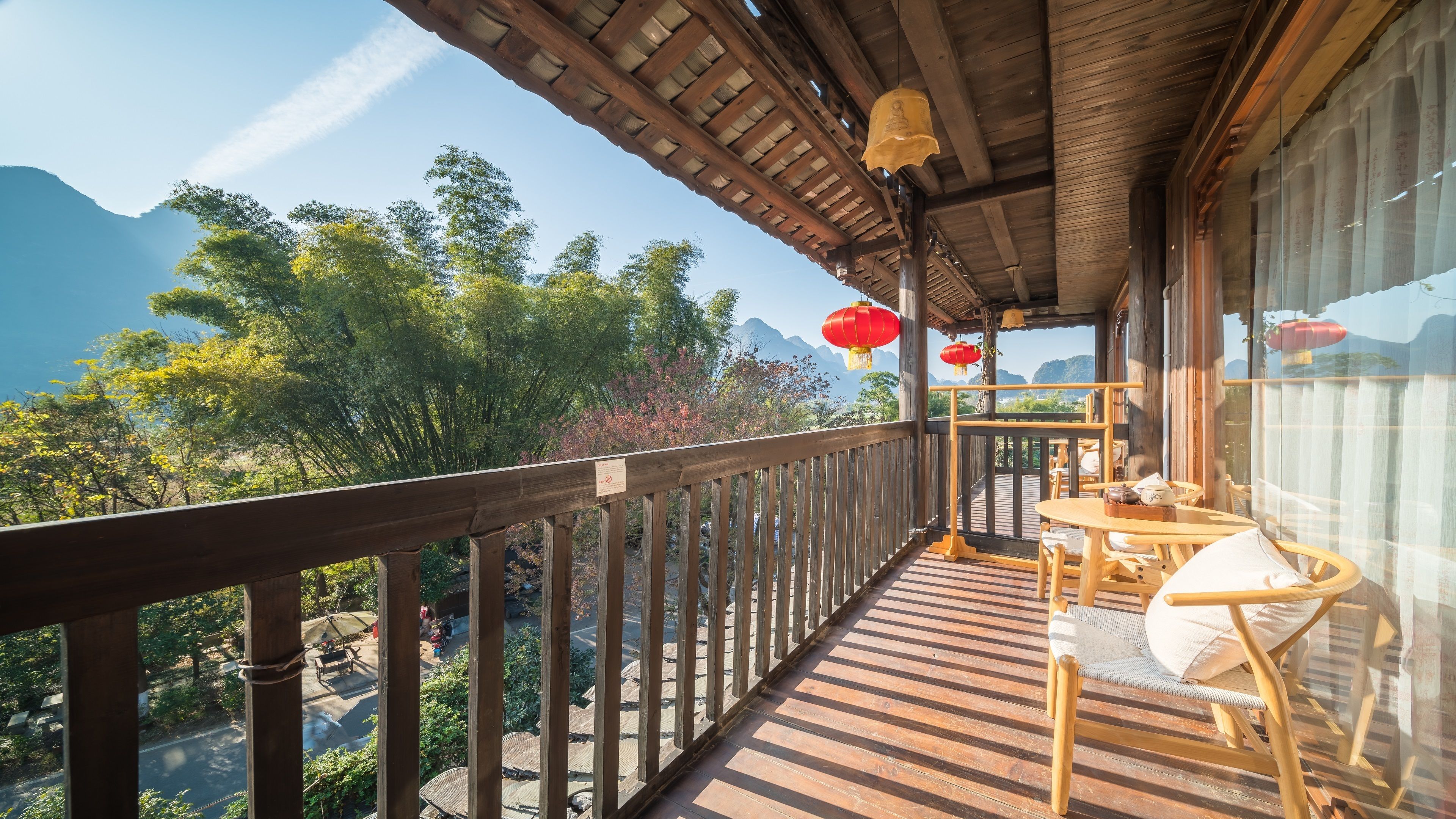 Un balcon en bois offrant une vue sur les montagnes et les arbres.