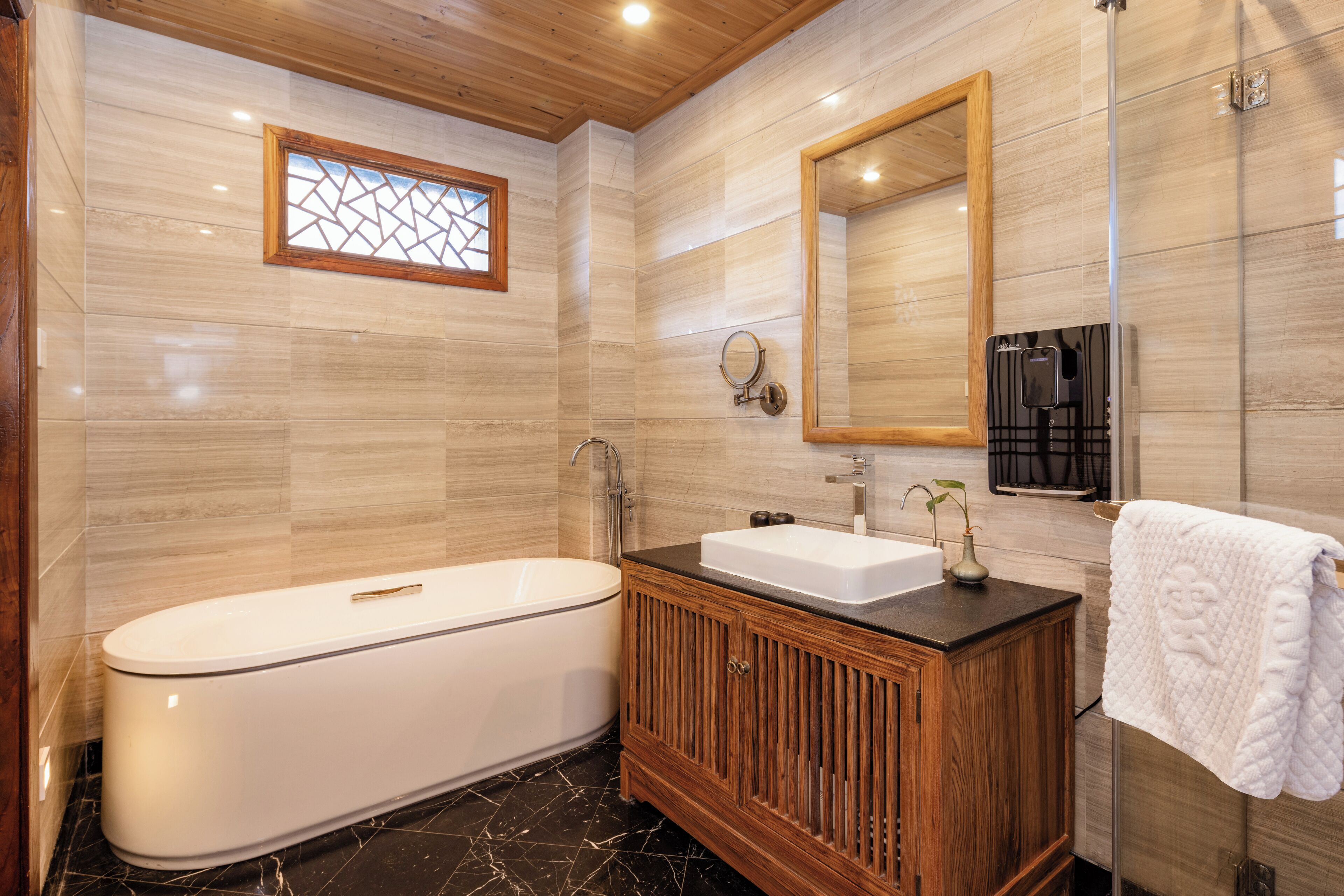 Un baño moderno con una bañera independiente, un tocador con lavabo y un espejo grande.