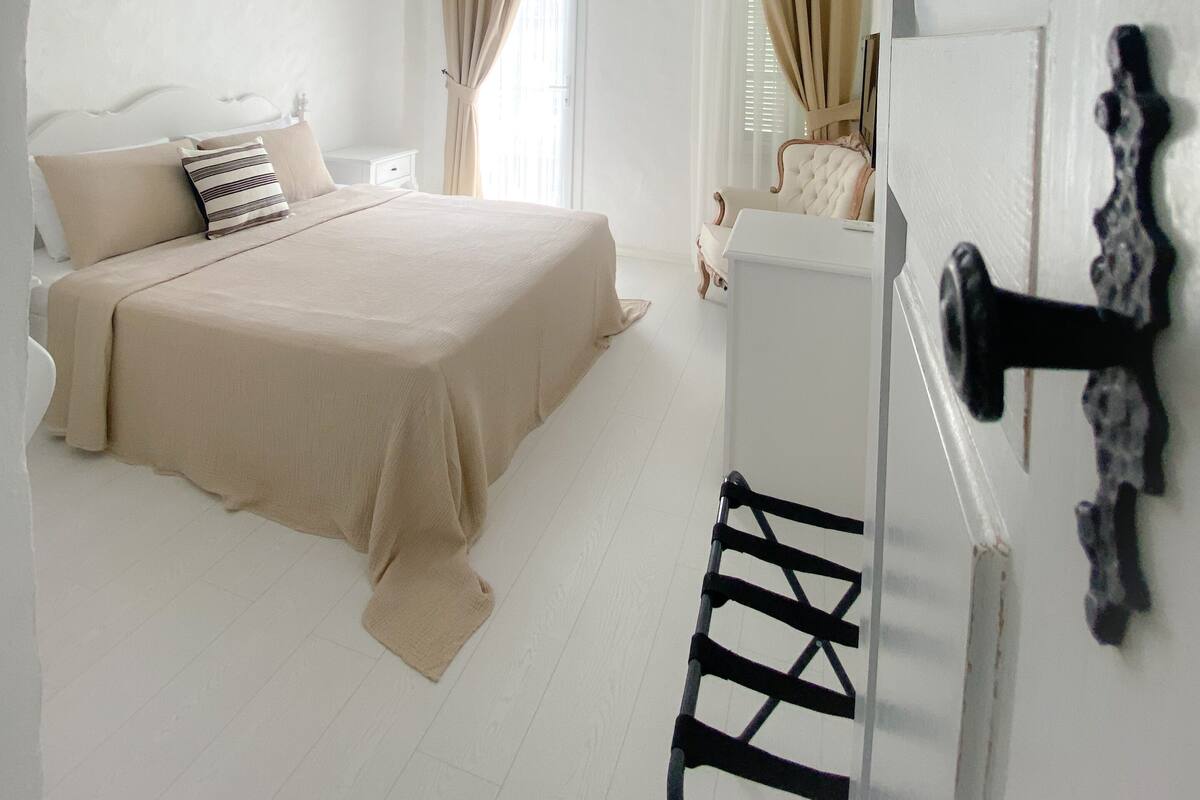 A bedroom with a bed, bedside table, and a dresser.
