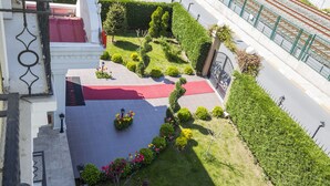 A landscaped courtyard with a red carpet, trimmed hedges, and a variety of flowers. - Pendik Marine Hotel (Istanbul)