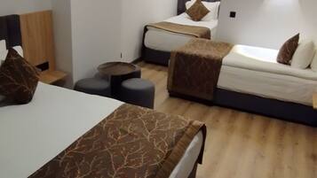 Una habitación de hotel moderna con dos camas, una mesita y un espacio para sentarse.