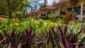A resort with multiple buildings, lush gardens, and tropical plants. - Pranee Beach Bungalows (Takua Pa)